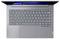 Vue de dessus d'un ordinateur portable Lenovo avec le clavier légèrement ouvert, montrant le clavier, le grand pavé tactile et le bord de l'écran rétroéclairé en bleu.
