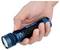 Une main tient une lampe de poche bleue avec les mots « OLIGHT » et « Seeker 4 » dessus, le pouce appuyant sur un bouton noir près de l'avant.