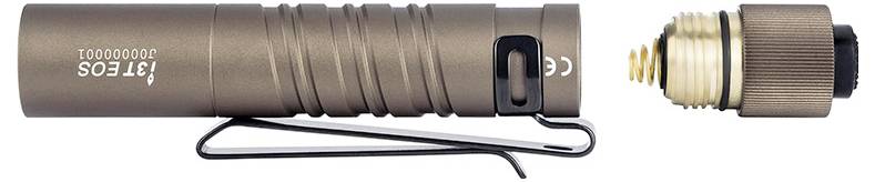 Une petite lampe de poche cylindrique marron avec une pince de poche. Le capuchon arrière de la lampe de poche est dévissé et placé à côté de celle-ci, montrant la batterie.