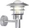 Un luminaire d'extérieur moderne monté sur le mur avec une finition en métal argenté et un verre entourant l'ampoule, illuminant doucement.
