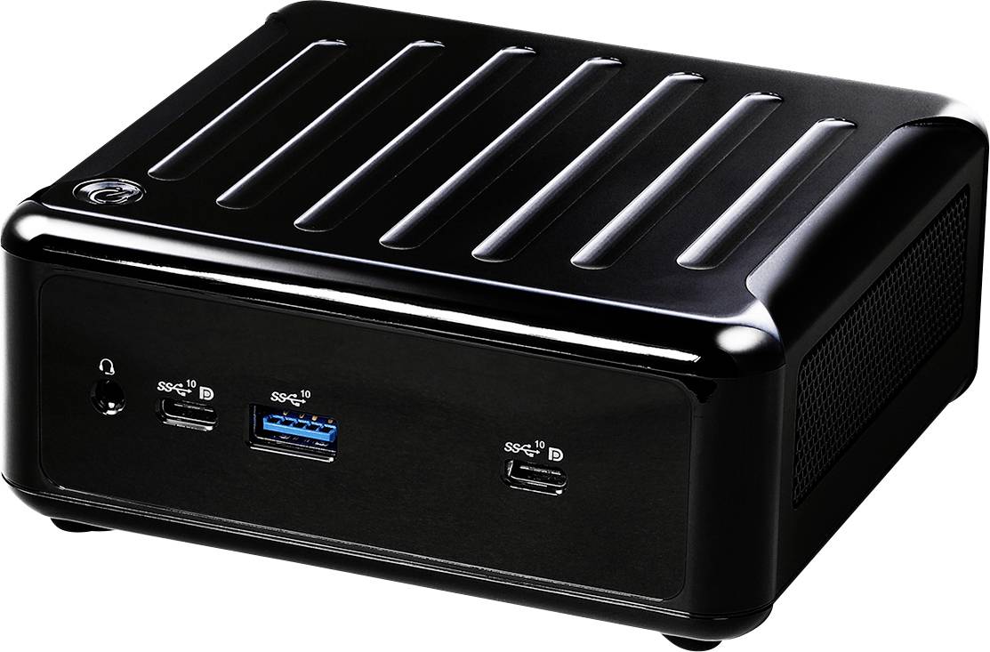 « Un mini PC noir avec divers ports incluant USB et des prises audio, posé sur une surface réfléchissante. »