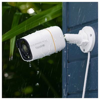 « Une caméra de surveillance montée sur un mur extérieur sous la pluie, capturant des images d'extérieur malgré les conditions humides. »