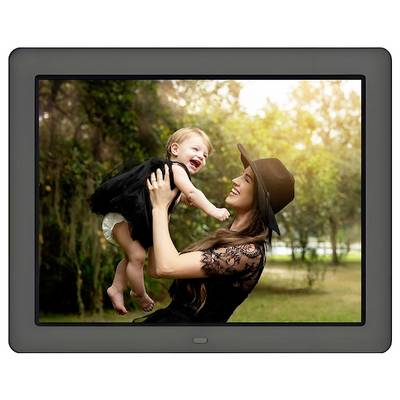 Une femme en robe noire et chapeau soulève un bébé souriant dans un parc, entourée d'arbres et d'une lumière chaude et douce.