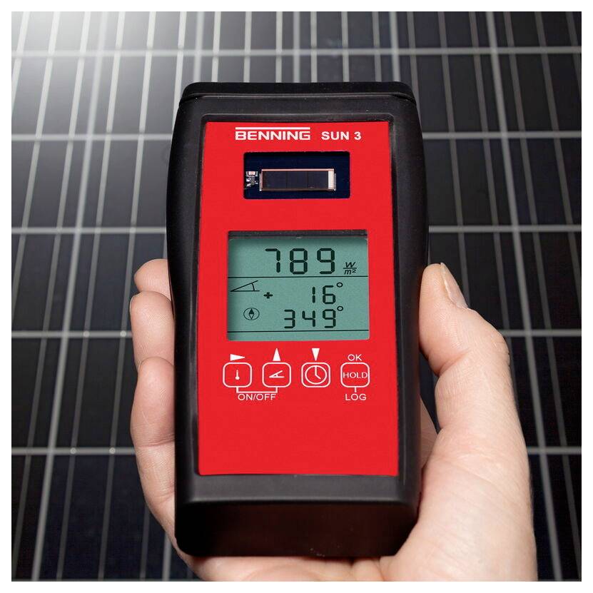 Une main tient un radiomètre solaire numérique affichant 789 W/m², 16°C, 349°. Des panneaux solaires sont visibles en arrière-plan.