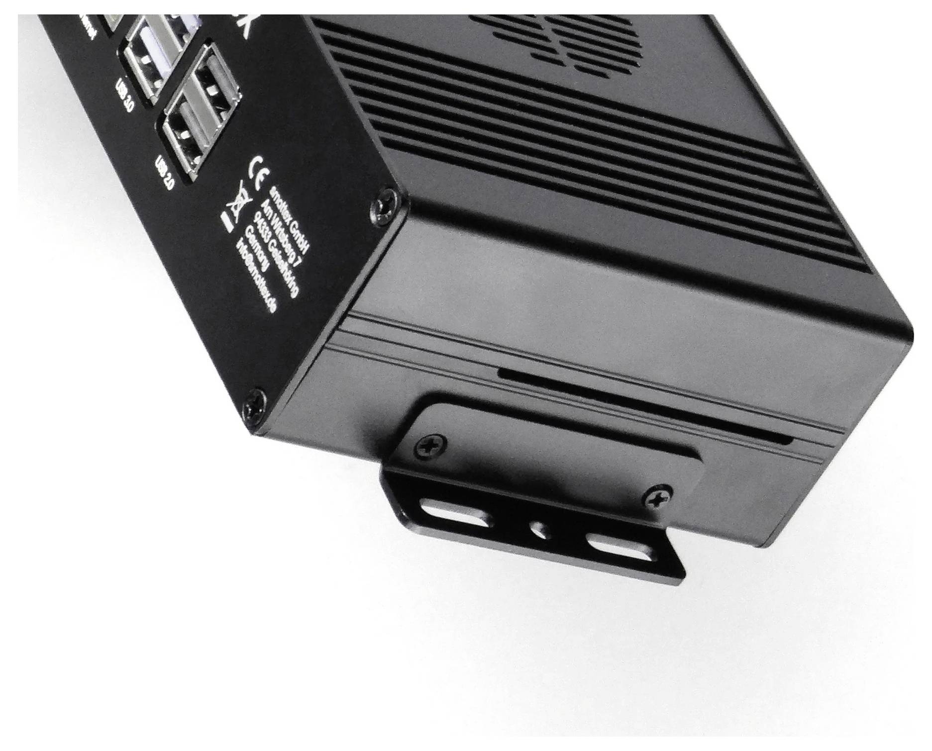 Un appareil électronique noir avec plusieurs ports, des fentes de ventilation et un support de montage, vu sous un angle, mettant en évidence sa connectivité et son design.