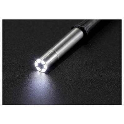 Gros plan d'une lampe de poche argentée projetant un faisceau lumineux brillant sur une surface sombre.