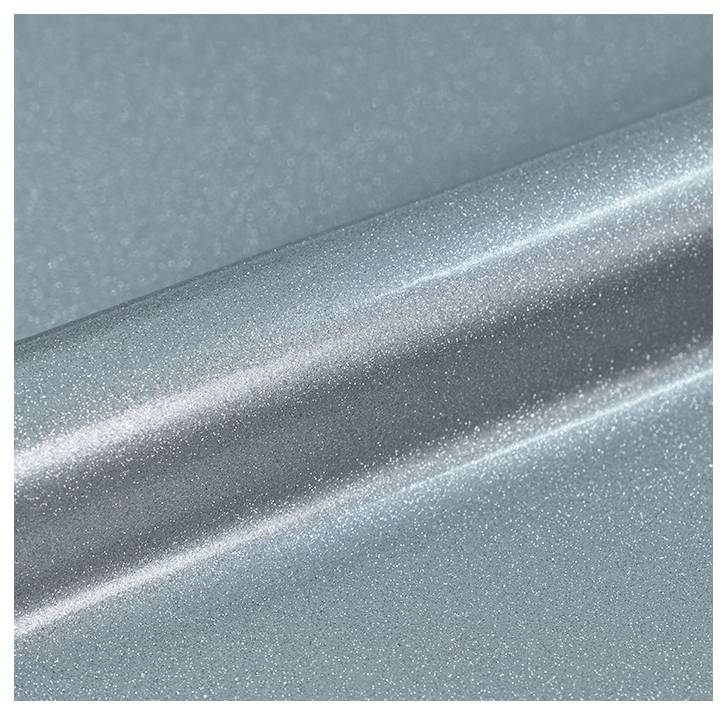 Un gros plan d'une surface argentée brillante et métallisée avec un fini lisse et réfléchissant. La texture semble légèrement granuleuse.