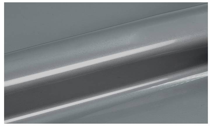 Un gros plan d'une surface grise lisse et brillante avec un léger reflet nacré.
