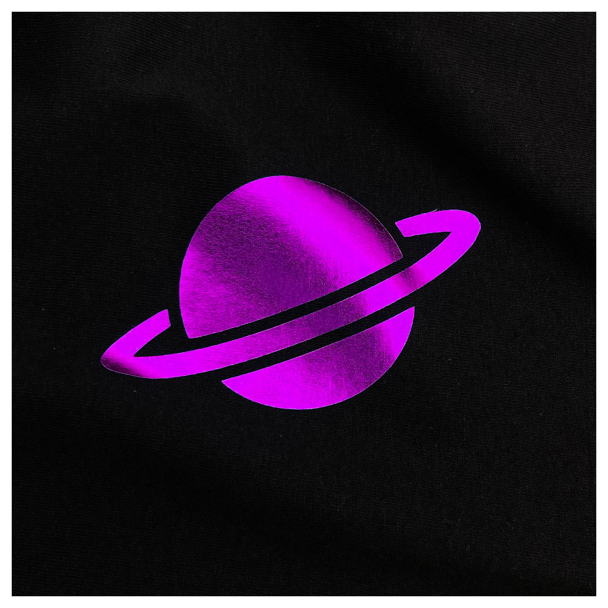 Une planète rose brillante avec un anneau, ressemblant à Saturne, sur un fond noir.