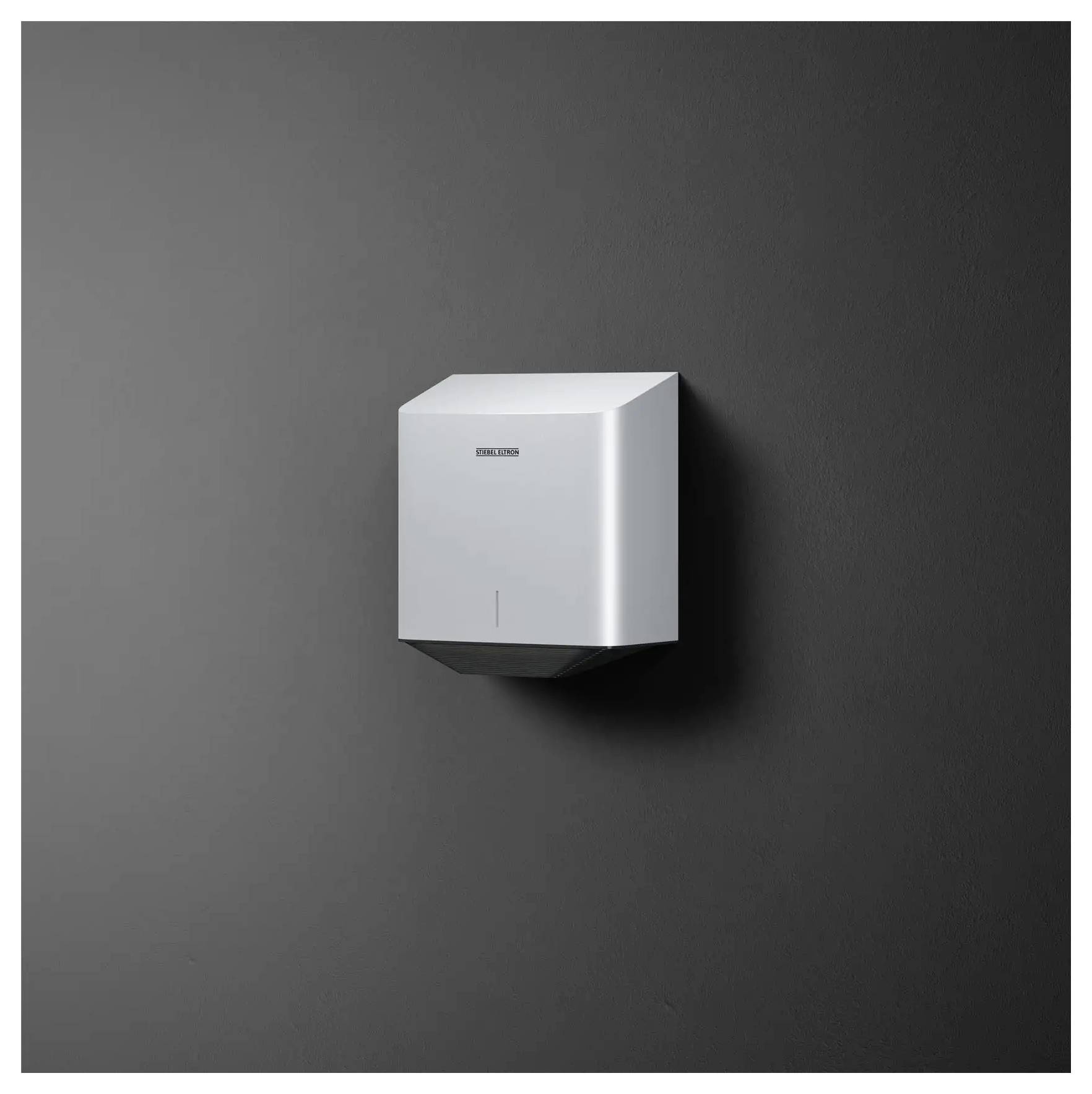 Un sèche-mains épuré et moderne fixé sur un mur foncé, présentant un design minimaliste avec un discret logo de marque sur la façade.