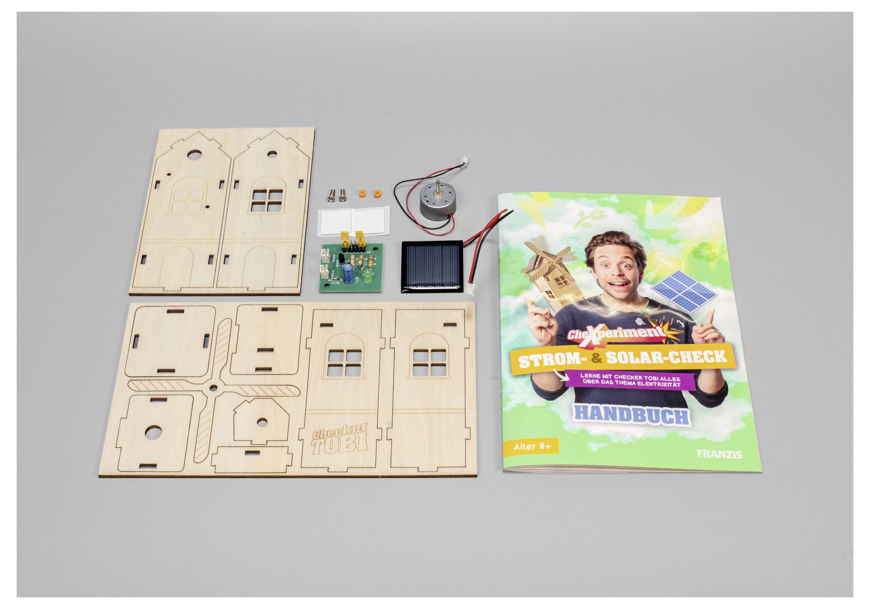 Kit « Contrôle de courant et d'énergie solaire » avec des pièces en bois, des composants électroniques et un manuel d'instructions pour construire un modèle fonctionnant à l'énergie solaire.