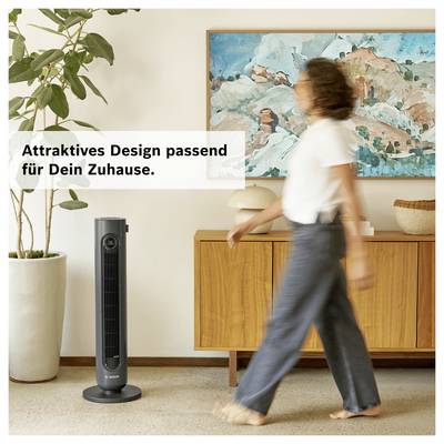 Purificateur d'air dans un élégant espace de vie avec une femme qui passe devant ; texte incrusté : « Design attrayant adapté à ta maison. »