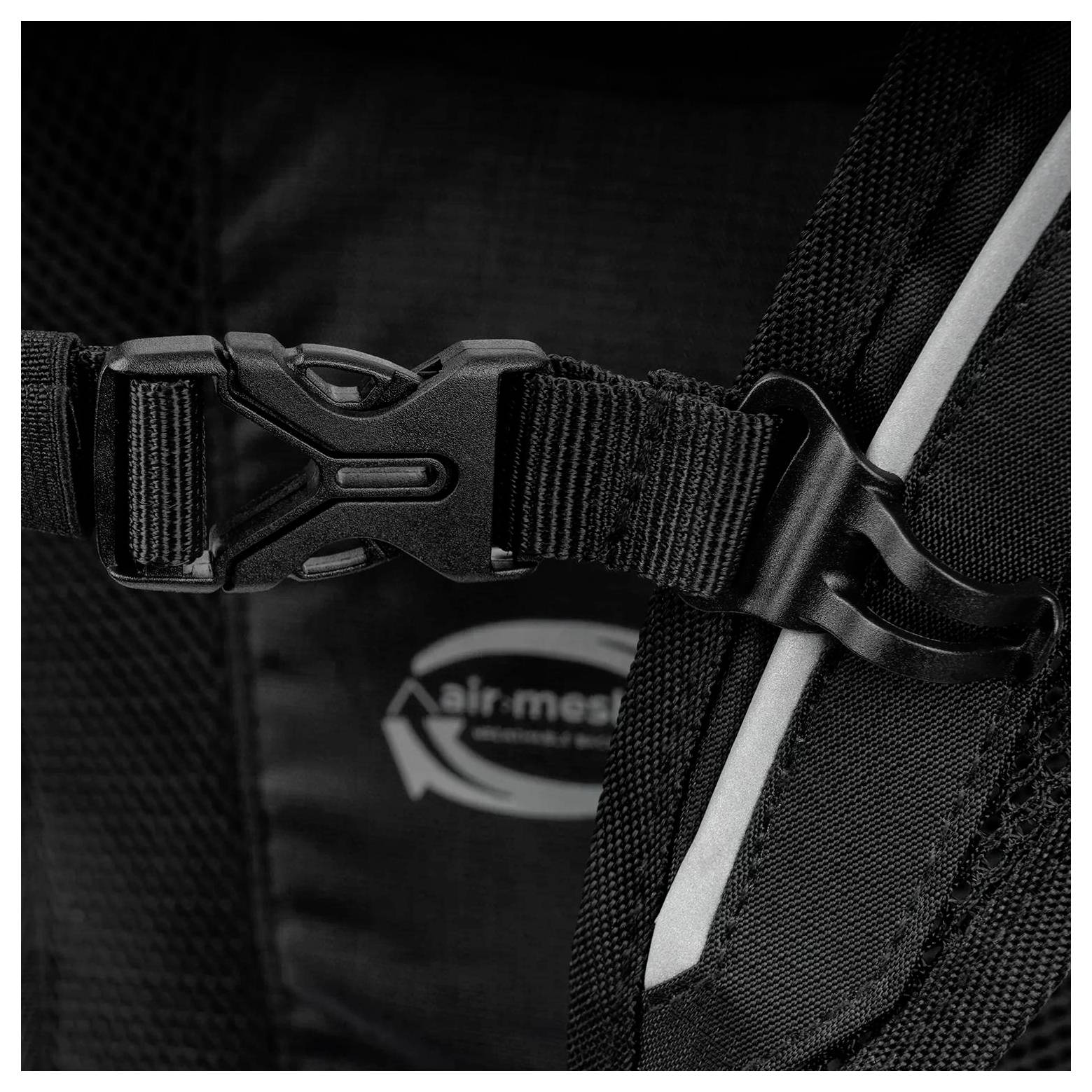 Un gros plan d'une sangle de sac à dos noir avec une boucle en plastique, présentant un logo « air-mesh » en arrière-plan, suggérant la respirabilité.