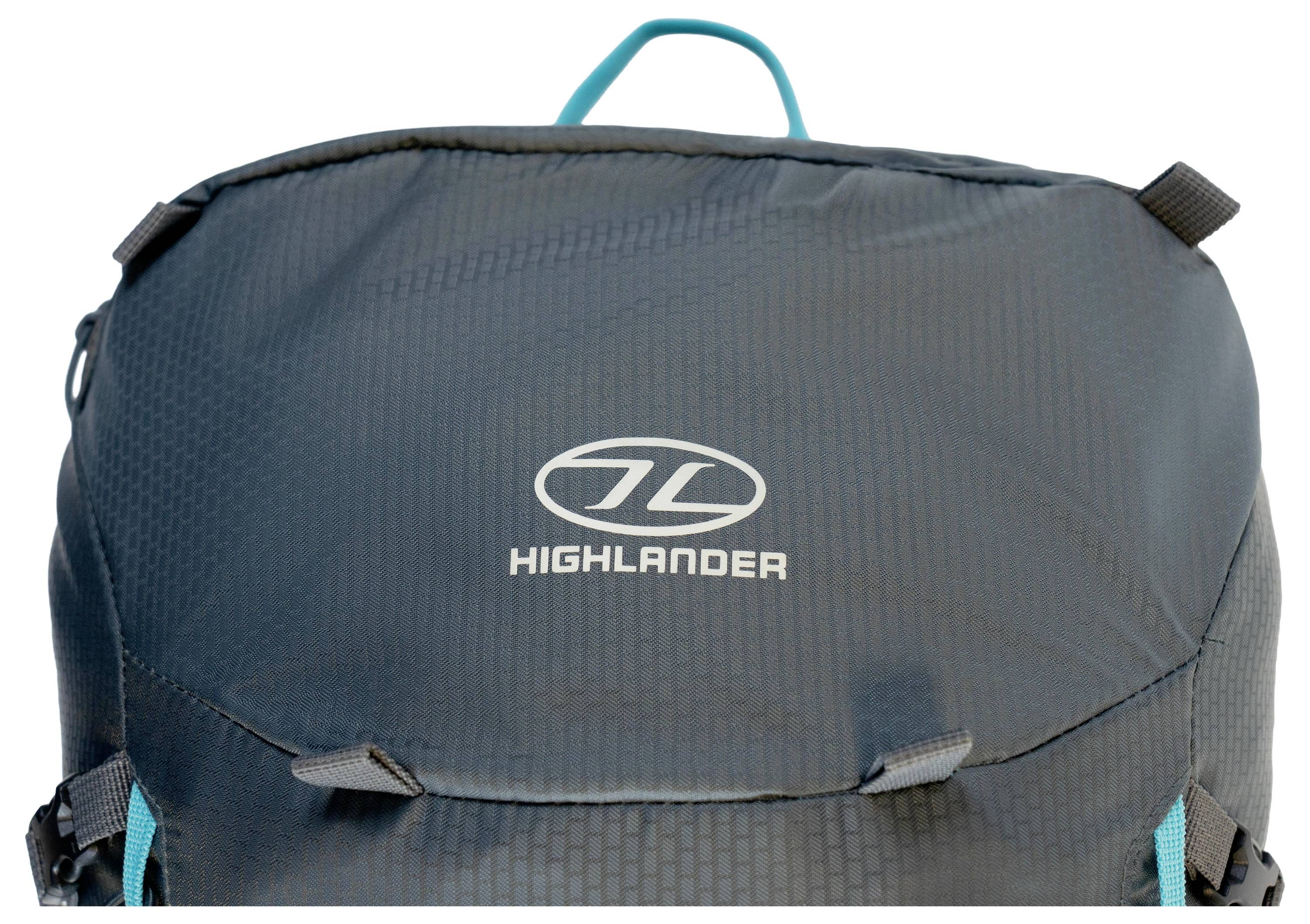 Gros plan d'un sac à dos de marque bleue « Highlander » montrant le logo et une partie du rabat avant avec deux boucles de sangle.