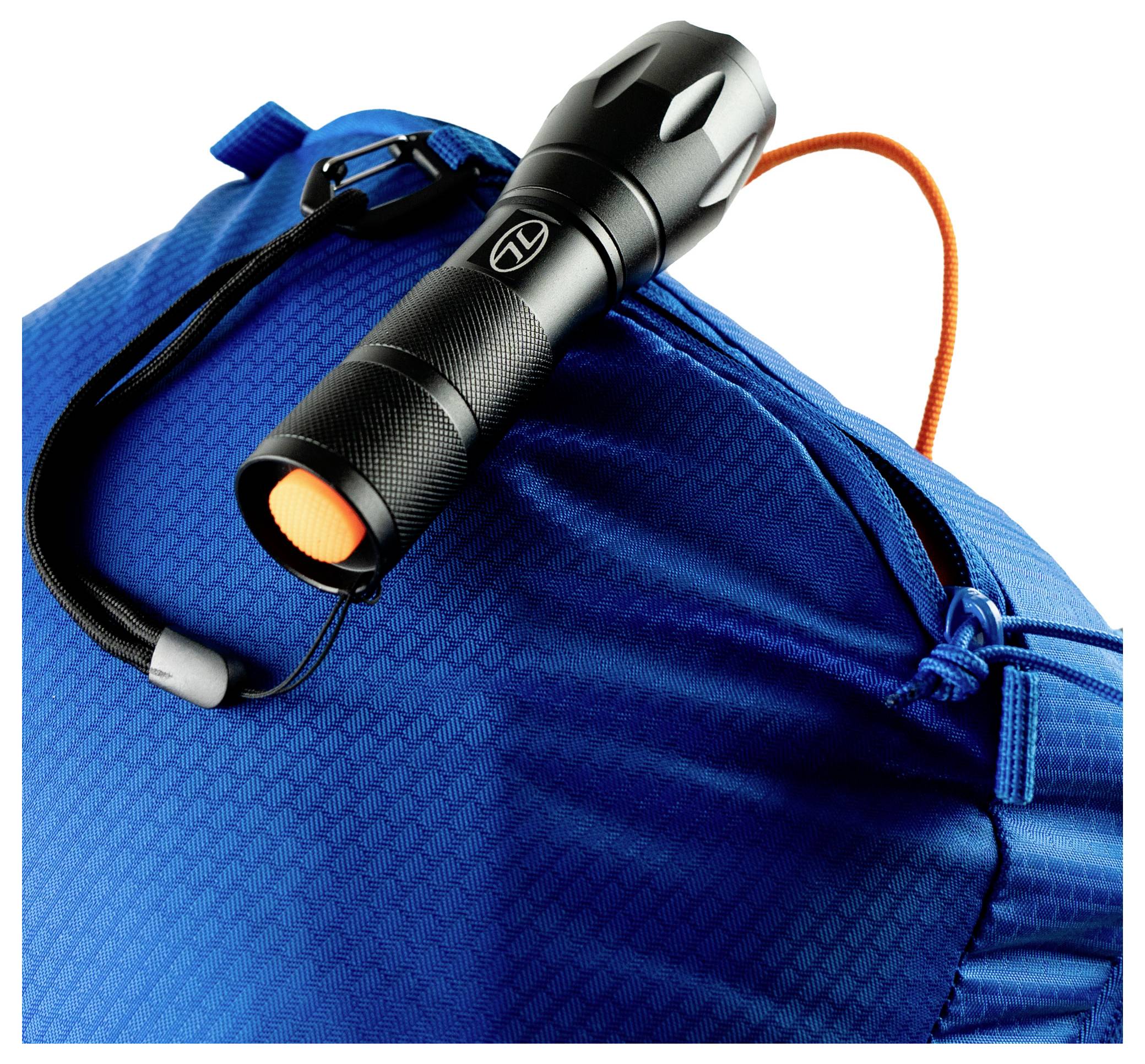 Une lampe de poche noire avec un bouton orange et une sangle de poignet, posée sur un sac texturé bleu avec un cordon de serrage orange.