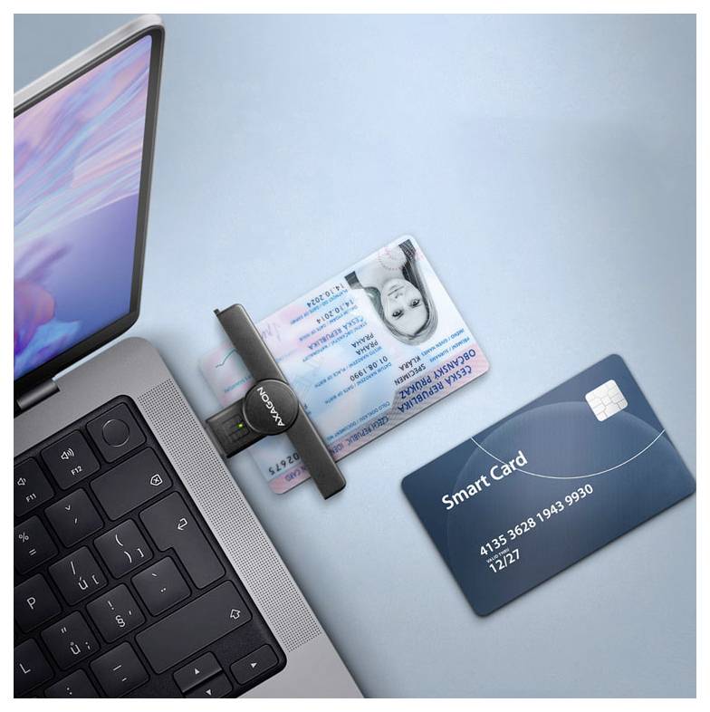 Ordinateur portable à côté d'une carte d'identité fixée dans un scanner de documents et une carte à puce bleue, suggérant une vérification d'identité ou de paiement.