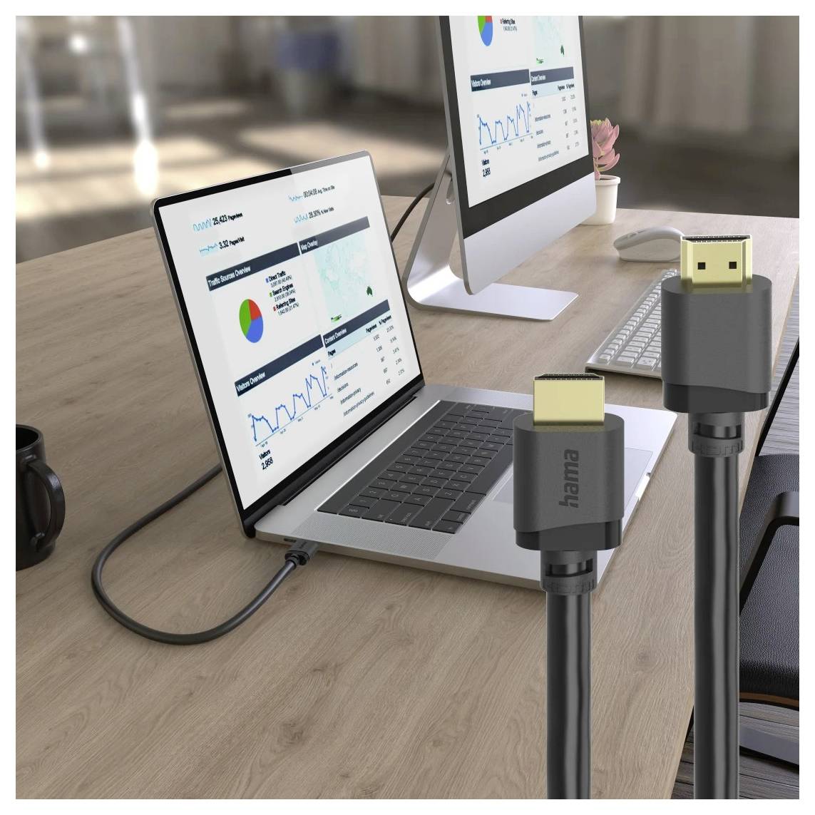 Câble HDMI sur table avec ordinateur portable et moniteur affichant des graphiques et des tableaux de données, suggérant une utilisation pour connecter et présenter du contenu.