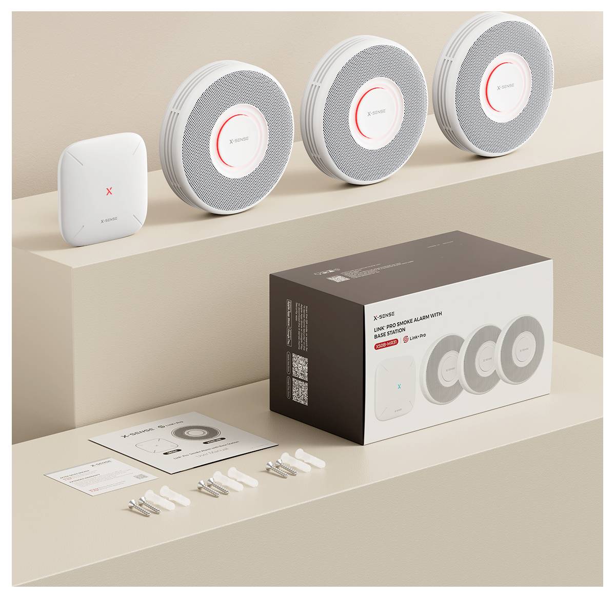 Kit mini détecteur de fumée X-Sense 10 ans affichant trois détecteurs de fumée ronds, un hub carré, boîte d'emballage, vis et manuels utilisateur.