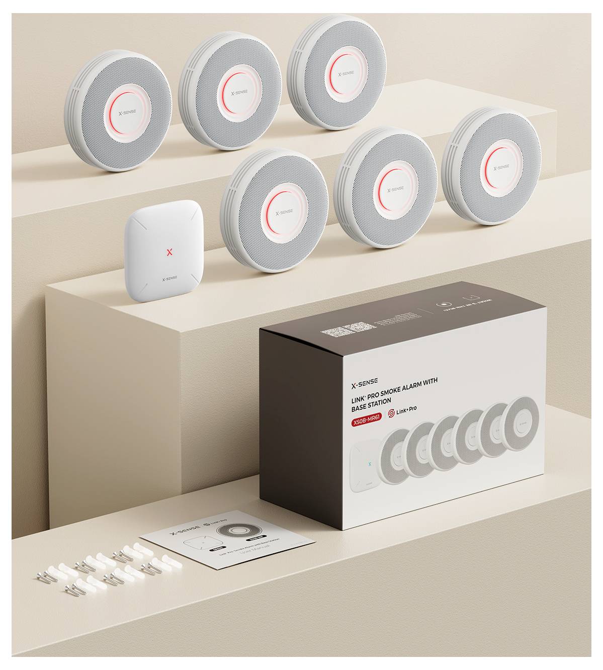 Ensemble de détecteurs de fumée composé de sept appareils ronds et d'un appareil carré, accessoires et manuel d'utilisation, sur des plateformes étagées.