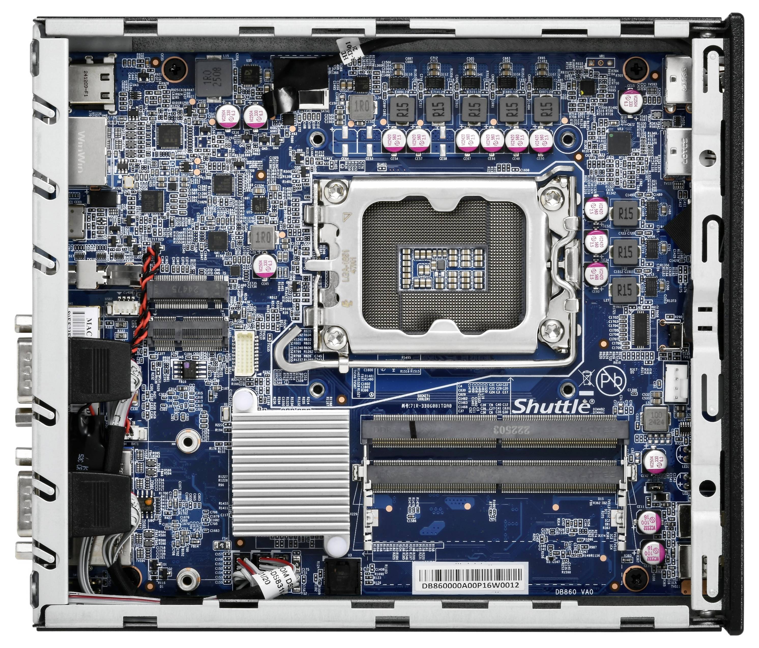 Gros plan d'une carte mère d'ordinateur avec un socket CPU Intel, des emplacements RAM, des dissipateurs thermiques et des connecteurs d'alimentation à l'intérieur d'un châssis compact.