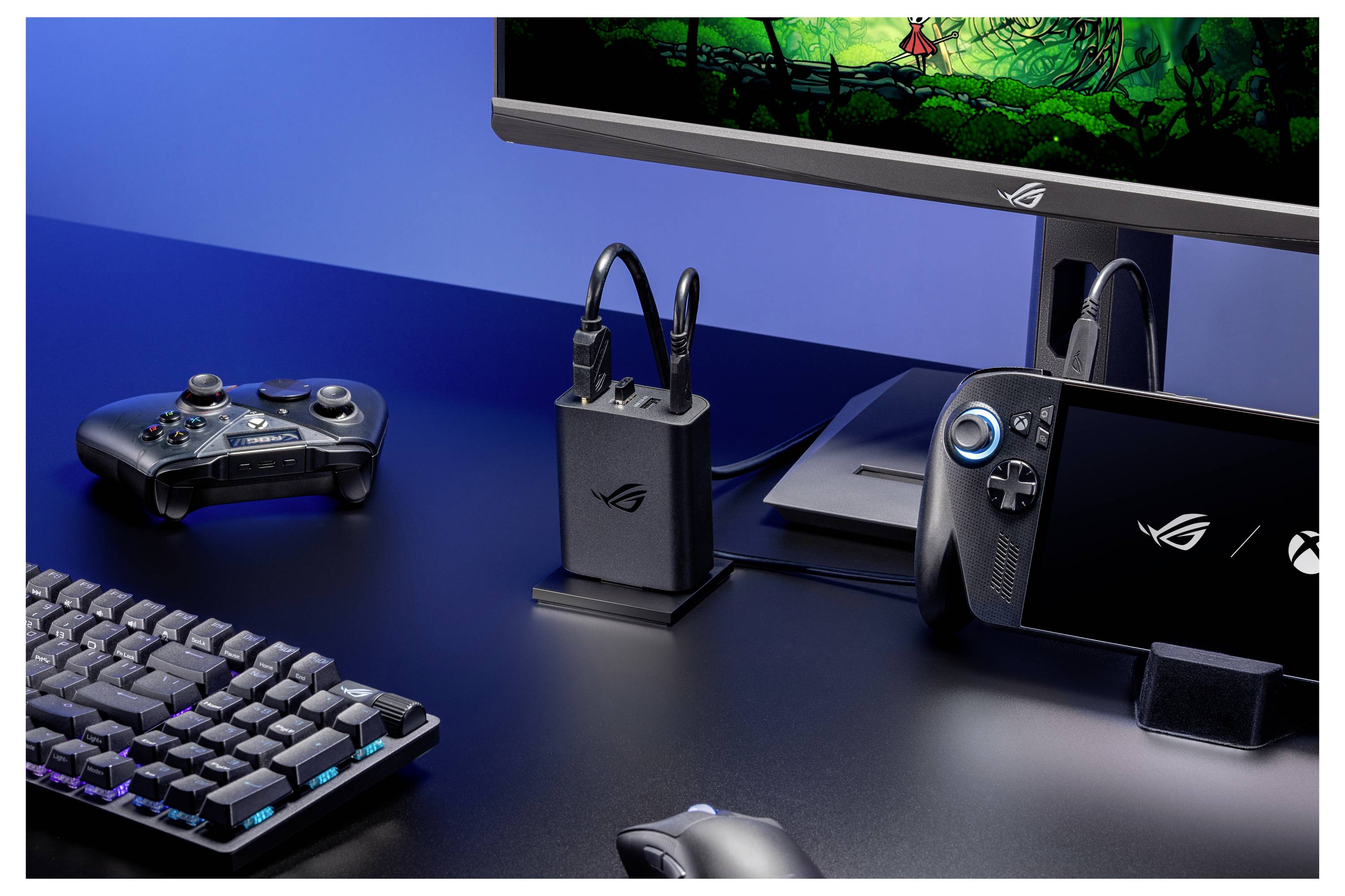 Une configuration de jeu comportant une manette de contrôle, un clavier, une souris et des moniteurs affichant un jeu, avec une station d'accueil et des accessoires.