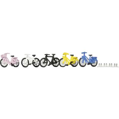 Cinq petits vélos de couleurs différentes (rose, blanc, noir, jaune et bleu) sont alignés à côté d'un petit support à vélos.