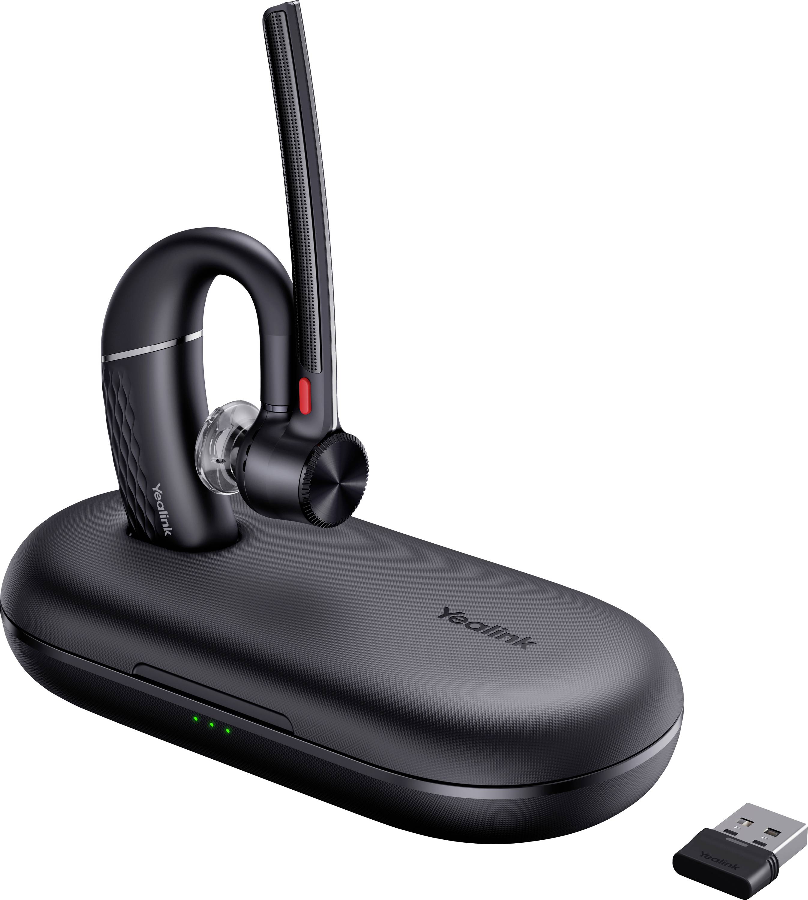 Un élégant casque sans fil noir avec microphone-perche flexible, posé sur un socle de recharge, accompagné d'une clé USB pour la connectivité.