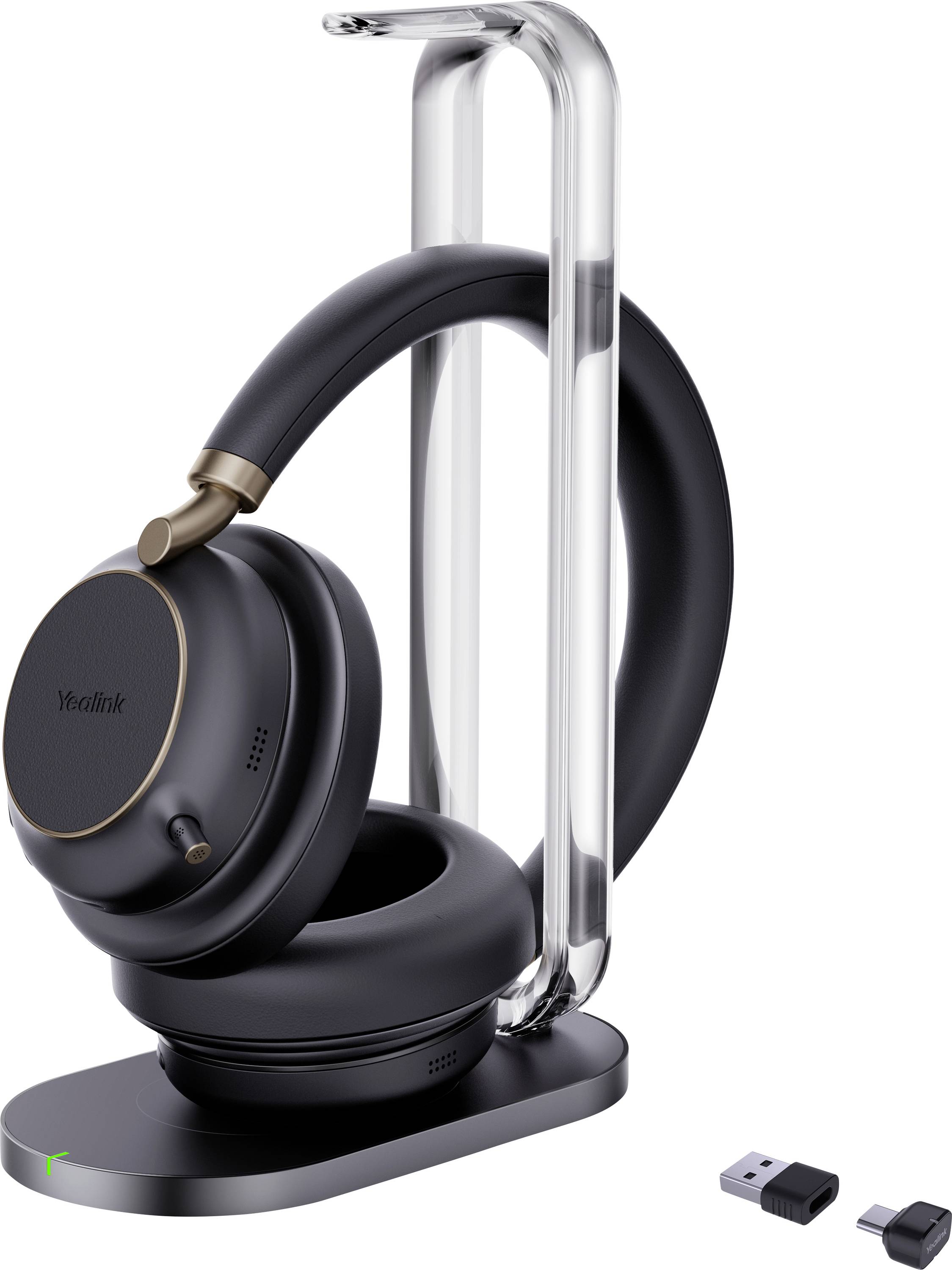 Un casque supra-auriculaire noir avec des accents dorés repose sur un support élégant. À côté, une petite clé USB est exposée, indiquant la connectivité sans fil.