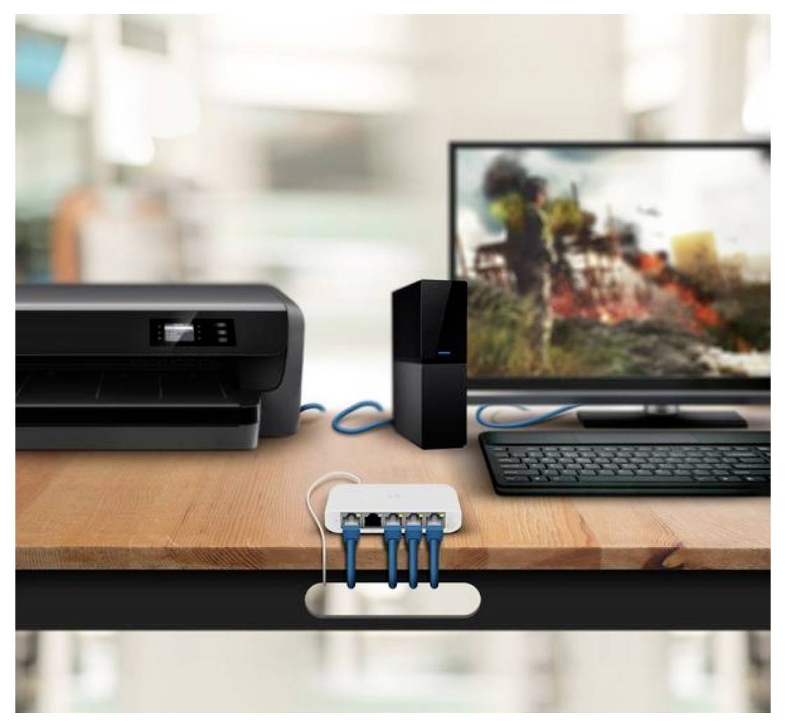 Un bureau avec un ordinateur de bureau, une imprimante et un concentrateur réseau. Des câbles bleus relient les appareils, montrant une configuration de bureau à domicile.
