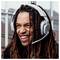 Gros plan d'un homme souriant aux dreadlocks longs portant un casque de jeu avec microphone.