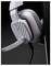 Gros plan d'un casque de jeu blanc et gris supra-auriculaire avec micro-bras, suspendu contre un fond sombre.