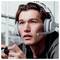 Jeune homme portant un casque de jeu qui se concentre tout en tenant une manette, probablement en train de jouer à un jeu vidéo.