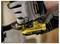 Une main gantée actionne un outil électrique Stanley Fatmax V20 jaune, ce qui suggère une utilisation dans les travaux de construction ou de réparation.