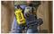 Une personne portant des gants tient un pistolet à clous jaune dans un environnement de construction, mettant en évidence la conception ergonomique et l'utilisabilité de l'outil.
