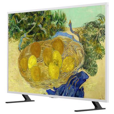 Téléviseur à écran plat affichant une nature morte d'un panier tressé contenant des fruits jaunes, avec un feuillage vert et un fond de tissu bleu.