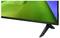 Gros plan d'un téléviseur à écran plat ou d'un moniteur avec un écran vert, une bordure noire et un support incliné sur un fond blanc.