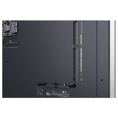 Vue arrière d'un téléviseur à écran plat ou d'un moniteur montrant les points de montage, les ports et les panneaux de ventilation sur le boîtier arrière.