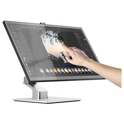 Une main utilise des gestes tactiles sur un grand moniteur affichant une interface de retouche photo avec une image de coucher de soleil et des contrôles d'édition.