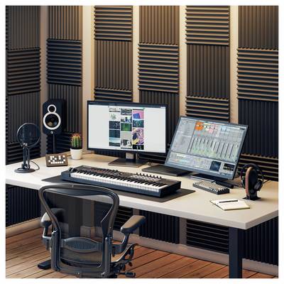 Un poste de travail de production musicale avec deux moniteurs affichant des logiciels, un clavier MIDI, des enceintes, un casque audio et des murs en mousse acoustique dans un studio.