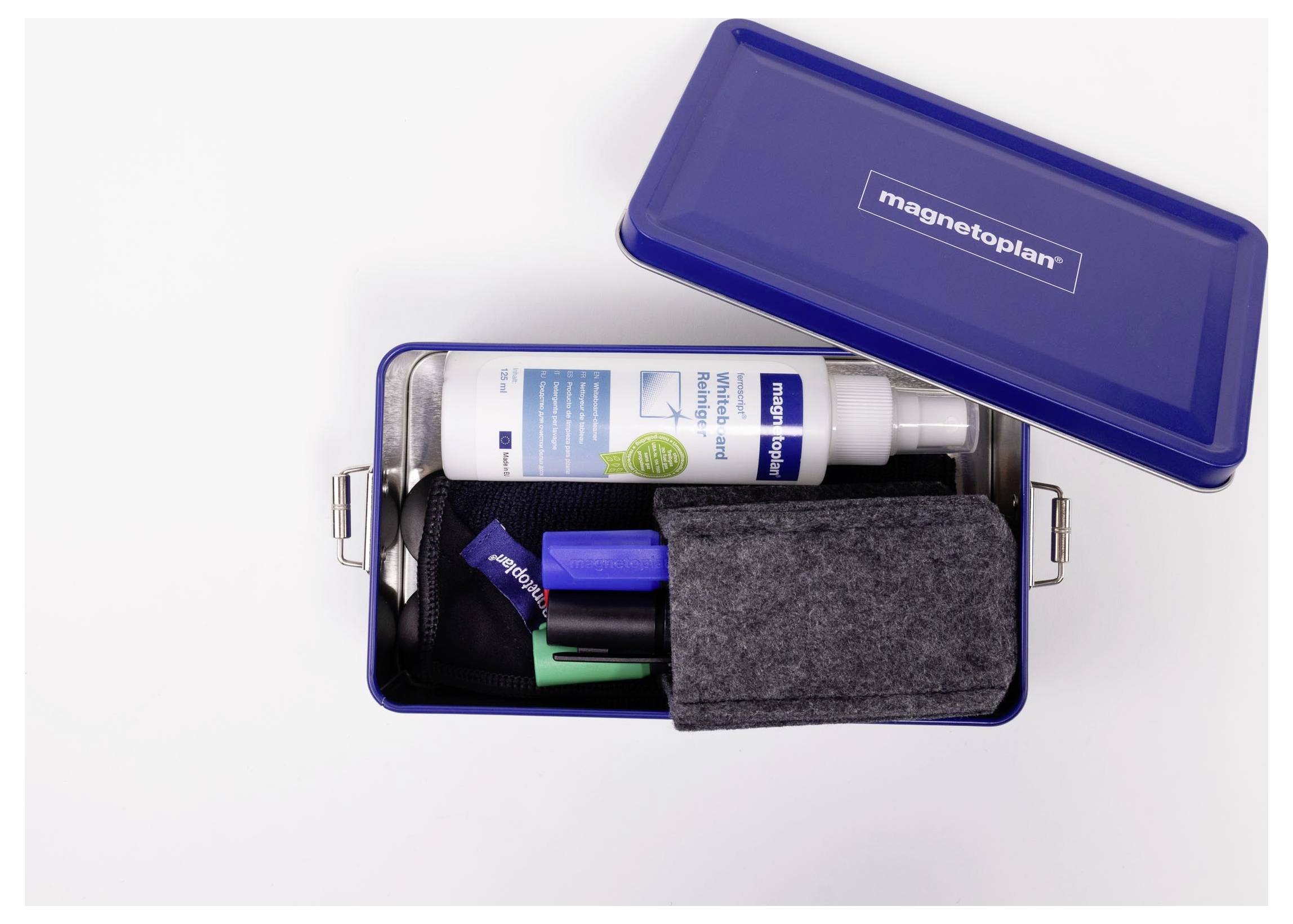 Organiseur magnétique en tôle bleu ouvert Magnetoplan avec stylos, marqueur, petit flacon, tissu et accessoires soigneusement rangés à l'intérieur.