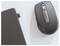 Une souris sans fil à côté d'un ordinateur portable avec un petit récepteur USB branché dans l'ordinateur