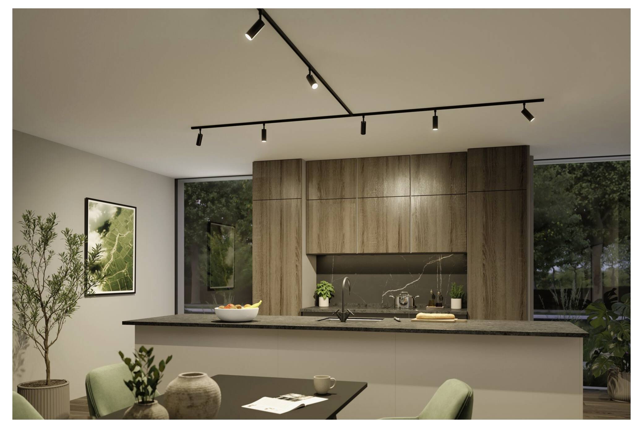 Cuisine et salle à manger modernes avec armoires en bois, îlot de cuisine avec plan de travail noir, éclairage sur rail, grandes fenêtres et chaises vertes dans un intérieur de maison contemporain.