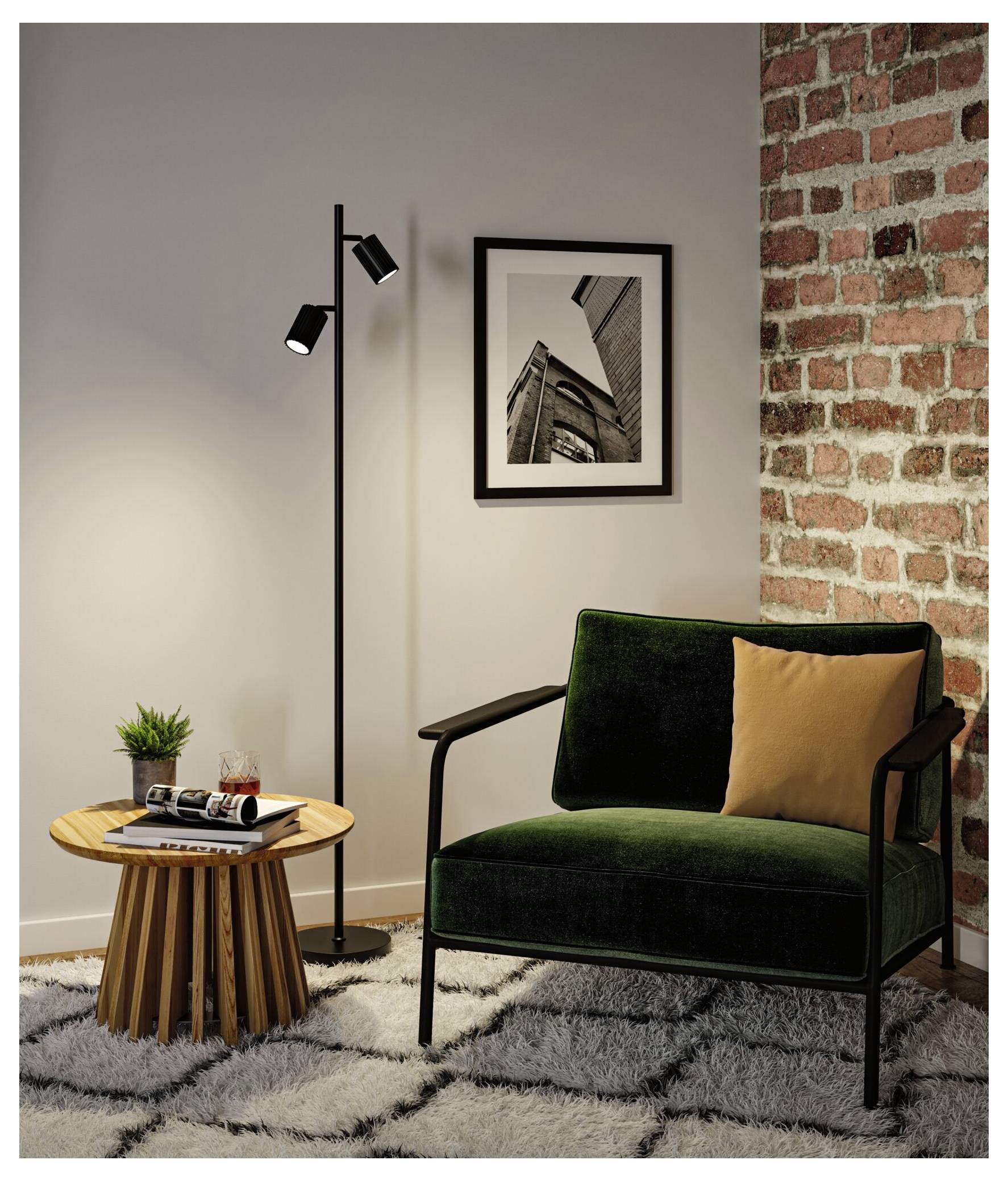 Coin de salon moderne avec un fauteuil vert, un lampadaire, une table d'appoint, un tableau encadré au mur et un mur d'accent en briques apparentes.