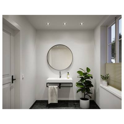 Salle de bain minimaliste moderne avec lavabo suspendu, miroir rond, serviette, plante en pot et lumière naturelle de la fenêtre.