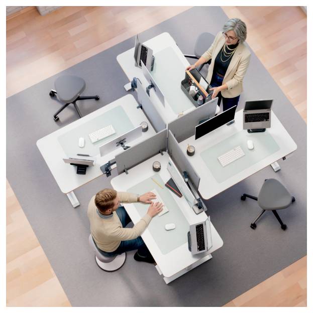 Vue de dessus de deux employés de bureau à des bureaux séparés dans un espace de travail partagé, l'un assis en train de taper et l'autre debout avec un sac d'ordinateur portable.