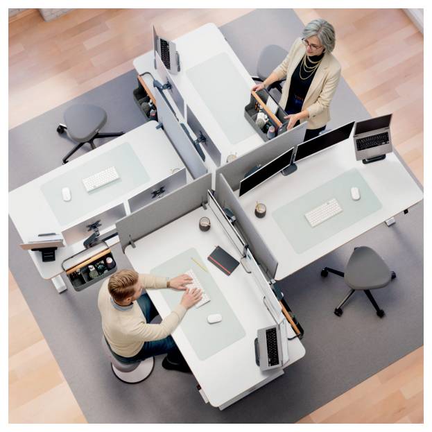 Vue de dessus de deux employés de bureau à des bureaux modulaires distincts dans un espace de travail partagé, chacun utilisant un ordinateur dans des postes de travail adjacents.