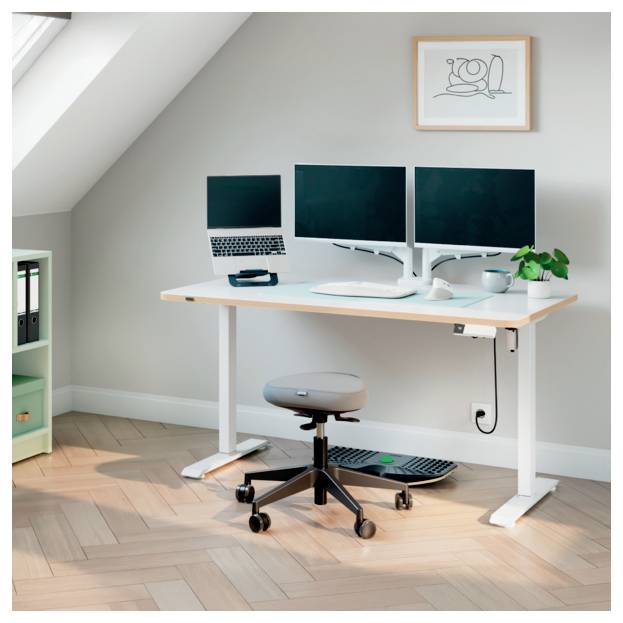 Configuration de bureau à domicile avec bureau debout, deux moniteurs, ordinateur portable, tabouret, clavier, souris et une petite plante dans une pièce mansardée lumineuse.