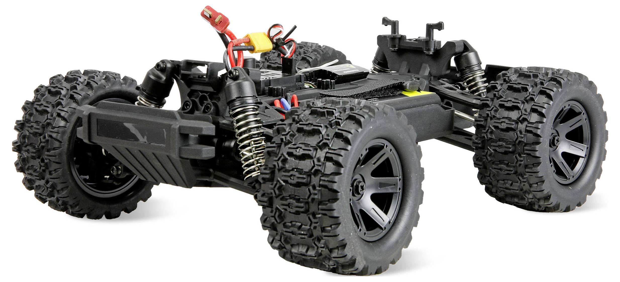 Un châssis de voiture RC tout-terrain noir avec de gros pneus à crampons, des ressorts de suspension et des câbles apparents sur un fond blanc.