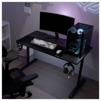Configuration de jeu avec un moniteur incurvé, un clavier, une souris, une tour PC RGB et un casque sur un bureau noir dans une pièce faiblement éclairée.