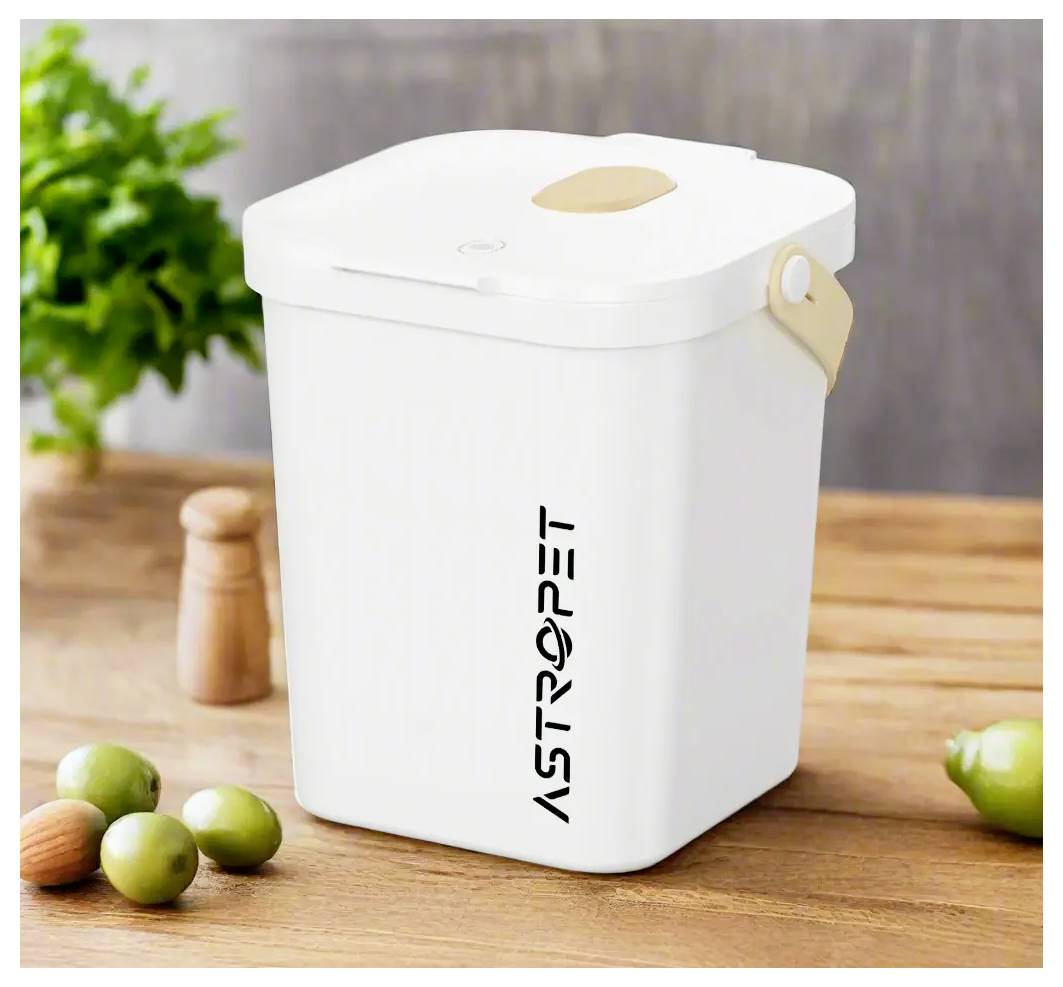Bac à compost blanc de forme carrée avec couvercle et poignée beige, étiqueté « ASTROPET », posé sur une table en bois avec de petits fruits et une plante en arrière-plan.